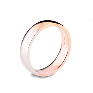 May include: A simple, polished, gold wedding band with a white gold band on one side and a rose gold band on the other side. The band is marked with "585 750".