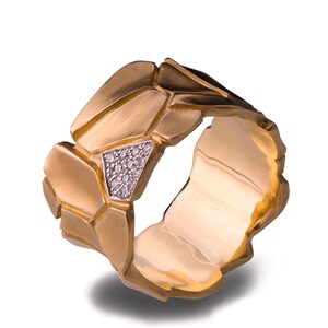 May include: A gold ring with a textured, geometric design. The ring is set with a small cluster of diamonds.