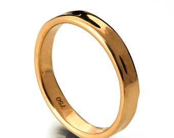 May include: A gold wedding band with a smooth, rounded surface. The band is marked with the number "750" on the inside.