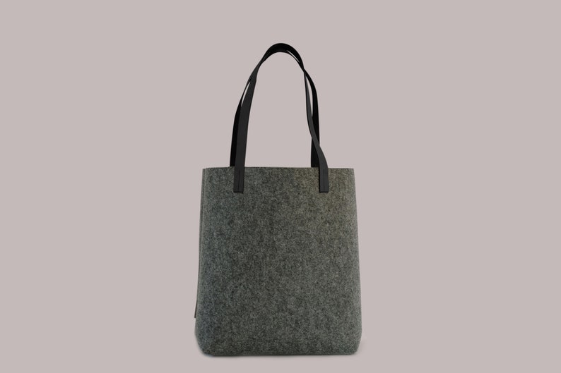 May include: A gray felt tote bag with black leather handles.