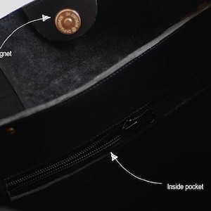 May include: Black leather tote bag with a zippered inside pocket and a magnetic closure.