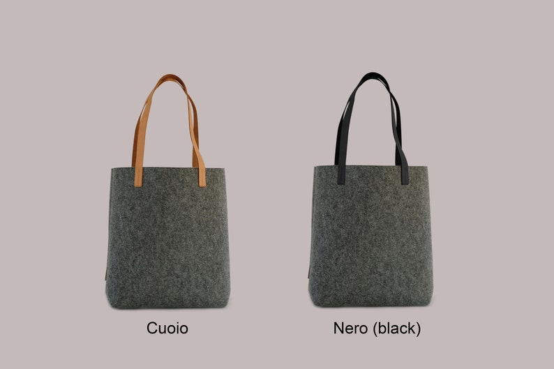 May include: Two gray felt tote bags with different handles. The bag on the left has brown leather handles, and the bag on the right has black leather handles. The bag on the left is labeled "Cuoio" and the bag on the right is labeled "Nero (black)".