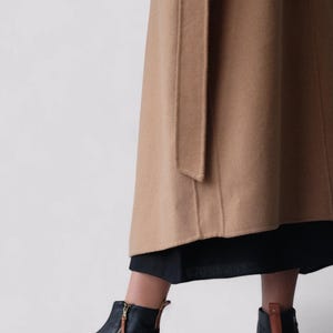 Pu&ograve; includere: Stivali da caviglia in pelle nera con cerniera laterale e linguetta in pelle marrone. Gli stivali hanno una suola piatta.