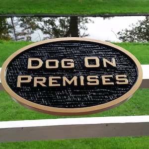 May include: A gold oval sign with black background and the text "DOG ON PREMISES" in gold lettering.