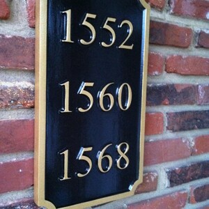 May include: A black and gold house number plaque with the numbers 1552, 1560, and 1568.