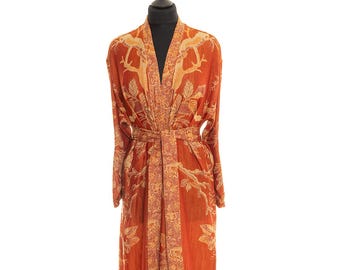 May include: A long, orange robe with a floral pattern. The robe has a tie belt and long sleeves.