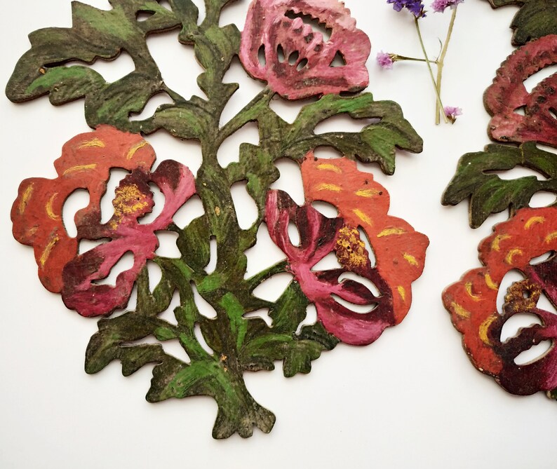 Peut inclure: Deux motifs floraux en bois sculpt&eacute;s de mani&egrave;re complexe, peints dans des tons de rouge, rose et vert. Les fleurs ont un design d&eacute;coup&eacute; et sont peintes dans un style rustique et vintage.