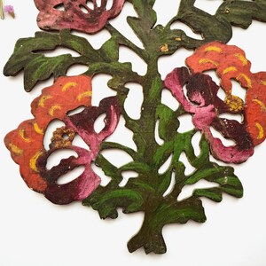 Peut inclure: Deux d&eacute;corations florales en bois d&eacute;coup&eacute;es et peintes de mani&egrave;re complexe. Les fleurs sont un m&eacute;lange de rose, rouge et orange avec des accents jaunes. Les feuilles sont vertes et l'arri&egrave;re-plan est blanc.