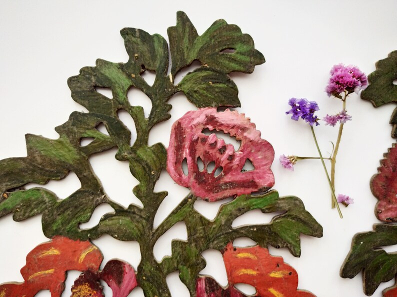 Peut inclure: Ensemble de trois d&eacute;corations murales florales. Les pi&egrave;ces sont en bois et peintes dans des tons de vert, rose et orange. Les fleurs sont stylis&eacute;es et ont un aspect vintage.