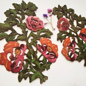 Peut inclure: Deux d&eacute;coupes florales d&eacute;coratives avec des motifs complexes. Les d&eacute;coupes sont peintes dans des tons de vert, orange et rose, ressemblant &agrave; des fleurs et des feuilles.