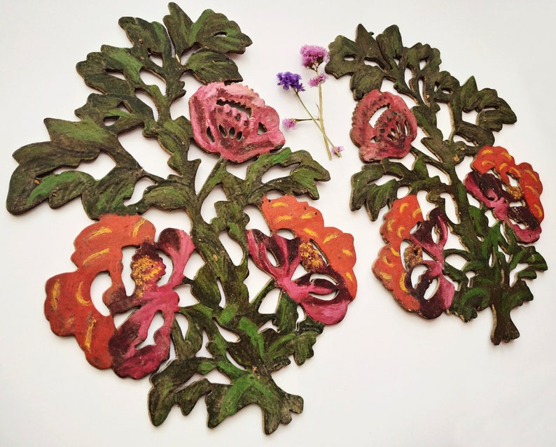 Peut inclure: Deux d&eacute;coupes florales d&eacute;coratives avec des motifs complexes. Les d&eacute;coupes sont peintes dans des tons de vert, orange et rose, ressemblant &agrave; des fleurs et des feuilles.