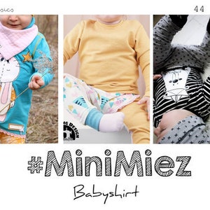 Könnte beinhalten: Ein blaues Baby-Shirt mit einem weißen Hasen-Motiv und Sternen. Das Shirt wird von einem Baby getragen, das eine orangefarbene Hose trägt. Das Bild zeigt auch ein gelbes Baby-Shirt und ein schwarz-weiß gestreiftes Baby-Shirt mit einem weißen Hasen-Motiv.