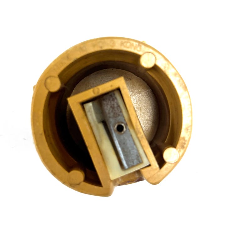 May include: A circular yellow plastic pencil sharpener with a central metal blade and a white plastic insert. The outer rim features embossed text that reads MADE IN HONG KONG. The sharpener has a hollow cylindrical body with internal supports.