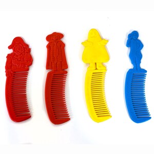 May include: Four colorful plastic combs. Each comb features a different character on top: a red pirate, a red gentleman, a yellow ghost, and a blue boy. The combs are red, yellow, and blue.