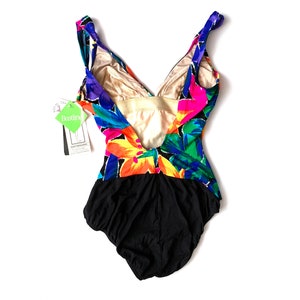 May include: A black swimsuit with a colorful floral print. The swimsuit has a deep V-neckline and a low back. The print features pink, yellow, green, blue, and purple flowers.