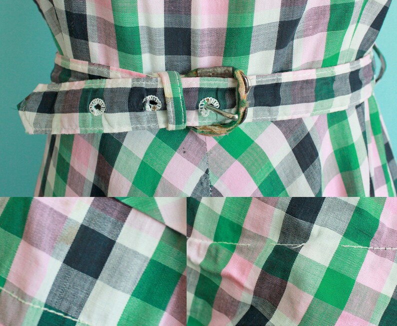May include: A green, pink, and black plaid dress with a brown belt. The dress has a fitted bodice and a full skirt.