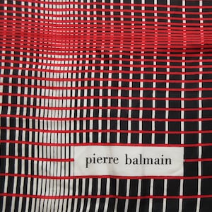 Può includere: Tessuto a quadri bianchi e neri con strisce rosse. Il tessuto ha un'etichetta con la scritta "pierre balmain".