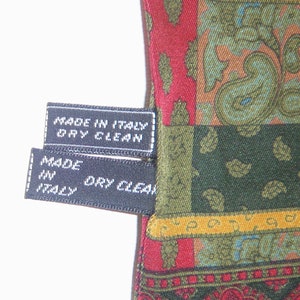 May include: Two black fabric tags with white stitching and text. The top tag reads "Made in Italy Dry Clean". The bottom tag reads "Made in Italy Dry Clean".