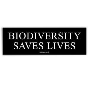 May include: A black rectangular sticker with the words "BIODIVERSITY SAVES LIVES" in white, sans-serif font. The text "driftless.earth" is printed in a smaller font below the main text. The sticker is designed to be eye-catching and informative.