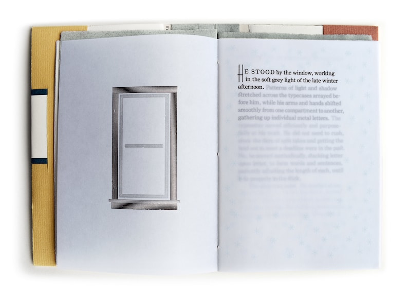 May include: An open book with a window illustration on the left page and text on the right page. The text reads "He stood by the window, working in the soft grey light of the late winter afternoon. Patterns of light and shadow stretched across the typecases arrayed before him, while his arms and hands shifted smoothly from one compartment to another, gathering up individual metal letters. The"