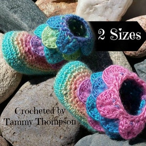 May include: Two pairs of crocheted slippers with colorful, layered flower designs. The slippers are made in two sizes. Crocheted by Tammy Thompson.