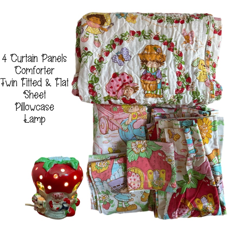 May include: A Strawberry Shortcake themed bedding set with a comforter, twin fitted and flat sheet, pillowcase, and lamp. The set features a white background with red strawberries, green leaves, and images of Strawberry Shortcake and her friends.