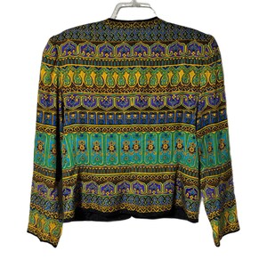 Pode incluir: Blazer estampado com acabamento preto. O casaco apresenta um design vibrante com motivos paisley e florais amarelos, verdes, azuis e roxos. O blazer de manga comprida est&aacute; pendurado num cabide branco.