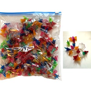 以下が含まれることがあります： カラフルなミニチュアプラスチッククリスマスツリーライトが入った透明なビニール袋。ライトは赤、オレンジ、緑、青、ピンクなど様々な色があります。袋の隣には小さなライトの山があります。
