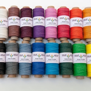 May include: Twenty spools of hemp twine in various colors, including natural, brown, red, purple, pink, orange, yellow, gray, blue, green, and black. Each spool has a label that reads "TRUE HEMP Hemp Creation www.hempcreation.com".