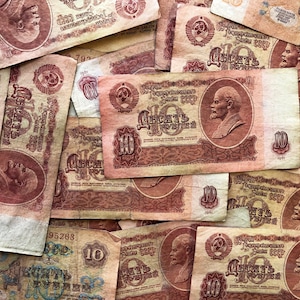 May include: A collection of vintage Soviet Union banknotes featuring the portrait of Vladimir Lenin. The banknotes are in various denominations, including 10 rubles. The banknotes are worn and faded, showing signs of age and use.