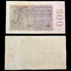 May include: An antique German Reichsbanknote, featuring ornate text and a large numeral "100" in the center. The bill is primarily beige with purple and black accents, and the serial number is visible. The reverse side is plain.