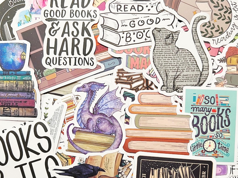 Pu&ograve; includere: Una collezione di adesivi colorati a tema libri. Gli adesivi includono pile di libri, un drago viola, una silhouette di gatto e il testo "Read Good Books & Ask Hard Questions."
