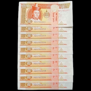 May include: A stack of ten Mongolian 1 Tugrik banknotes featuring a portrait of Genghis Khan. The banknotes are in good condition and have the serial numbers AB5795201 through AB5795210.