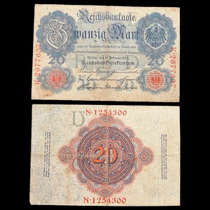 May include: Two antique German 20 Mark Reichsbanknote banknotes. The front features text in German, a large "20", and an eagle emblem. The back has a central "20" surrounded by ornate patterns and text. The banknotes are aged with visible wear.