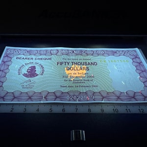 May include: A purple and green bearer cheque from the Reserve Bank of Zimbabwe for fifty thousand dollars. The cheque is dated February 1, 2006 and is valid until December 31, 2006. The cheque number is CH 1607586.