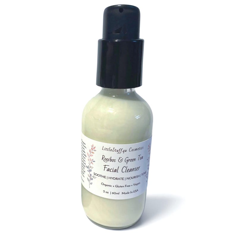 May include: A clear glass bottle containing a pale green facial cleanser with a black pump dispenser. The white label reads LittleStuff4u Cosmetics Rooibos & Green Tea Facial Cleanser, Soothe | Hydrate | Nourish | Tone, Organic + Gluten Free + Vegan, 2 oz | 60ml Made in USA.