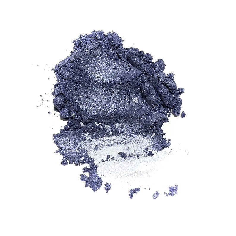 Puede incluir: Un mont&oacute;n suelto de sombra de ojos en polvo color &iacute;ndigo profundo con un acabado met&aacute;lico brillante. La textura es granular y apelmazada, mostrando un mont&iacute;culo concentrado de pigmento azul oscuro que se dispersa en part&iacute;culas finas.