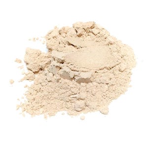 May include: A small, loose pile of fine, light beige cosmetic powder with a soft, matte texture. The powder is clumped together in some areas, showing a granular consistency with varying particle sizes spread across the surface.
