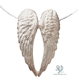 May include: Silver angel wings pendant necklace. The wings are detailed with a textured feather design.