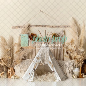 May include: A bohemian-themed photography backdrop featuring a white teepee with macrame details, surrounded by pampas grass, pillows, and decorative elements. The backdrop includes a wooden branch, dried flowers, and a neutral color palette.