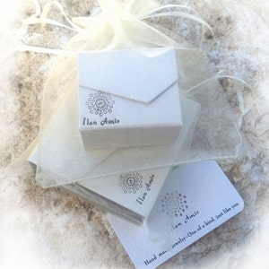 May include: A white box with a logo that says "Ilan Amir" and a white card with the text "Hand made jewellery. One of a kind, just like you" and the logo "Ilan Amir".