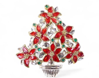 May include: A brooch in the shape of a Christmas tree, with red poinsettias, gold detailing, silver leaves, and green gems. The brooch is set in a silver pot. A festive holiday accessory.