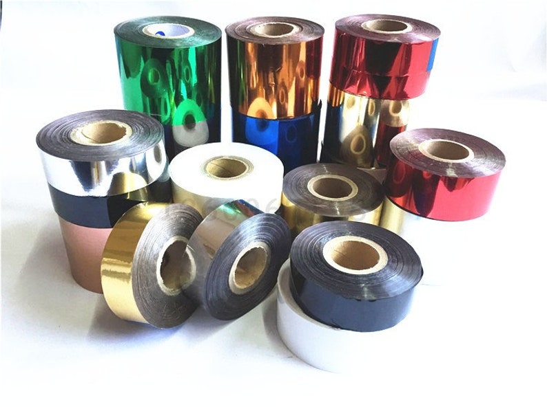 May include: Assortment of colorful rolls of foil ribbon for hot stamping. The rolls are in various colors, including gold, silver, red, green, and blue.