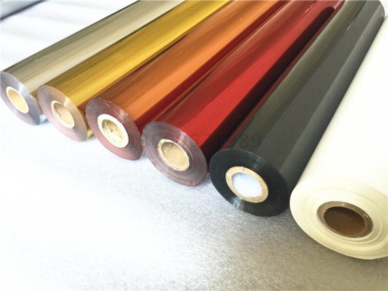 May include: Rolls of metallic foil in various colors, including gold, silver, red, and black. The foil is used for hot stamping or foil printing.