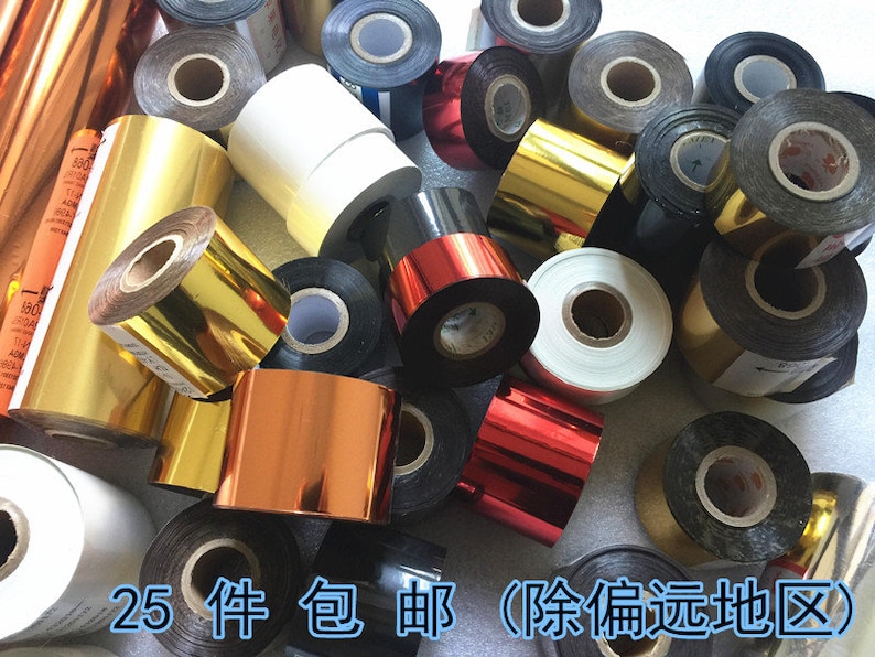 May include: Assortment of gold, silver, and black ribbon rolls. The rolls are various sizes and are arranged in a pile.