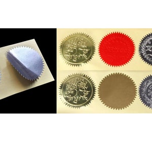 May include: A sheet of gold foil stickers with various designs. The stickers are round and have a scalloped edge. Some stickers feature a tree design, while others are blank or have text. The stickers are on a white background.