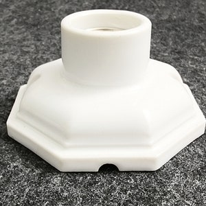 May include: White ceramic light socket with an octagonal base.