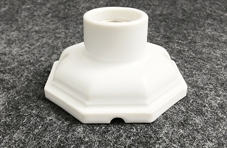May include: White ceramic light socket with an octagonal base.