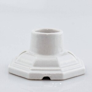 May include: White ceramic pen holder with a hexagonal base and a cylindrical top.