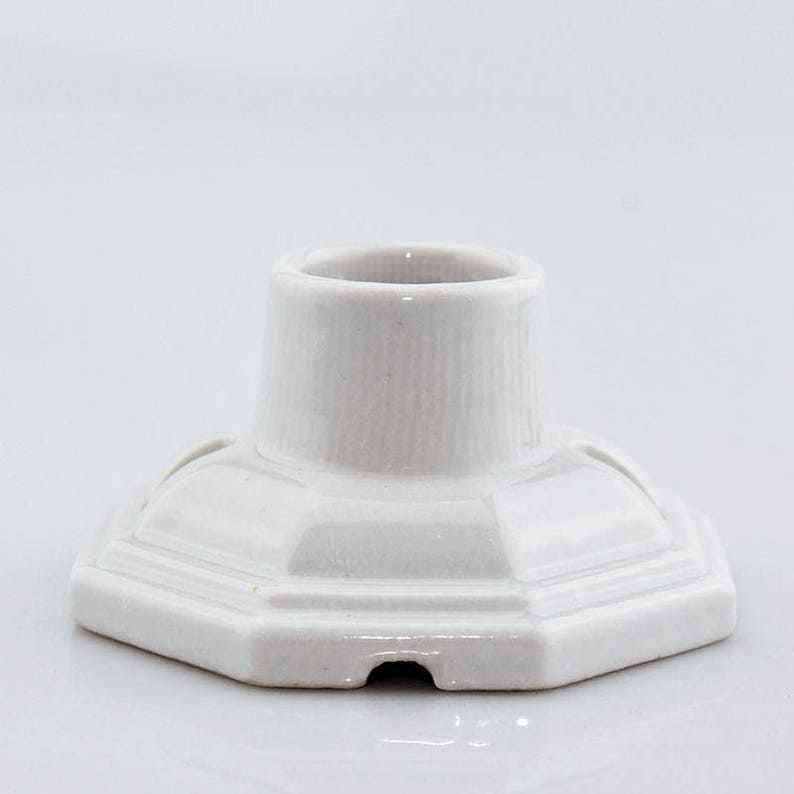 May include: White ceramic pen holder with a hexagonal base and a cylindrical top.